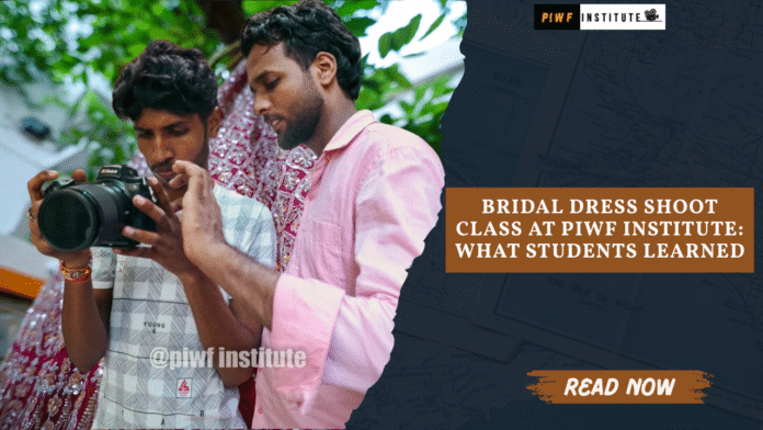 Two PIWF Institute students learning Nikon DSLR camera settings during a Bridal Dress Shoot Class in an outdoor courtyard, with a red heavily embroidered bridal lehenga hanging on a tree in the background. The image shows hands-on photography training at Patna Institute of Wedding & Filmmaking.